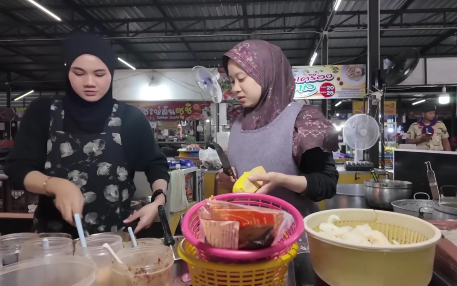 Perempuan menjual makanan dan hasil kerajinan di pasar Pattani