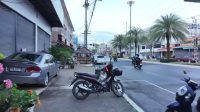Suasana jalan utama Pattani dengan motor dan aktivitas warga