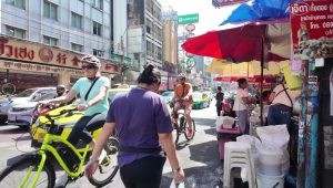 Wisatawan bersepeda di jalur alternatif yang tenang dan asri di Bangkok.