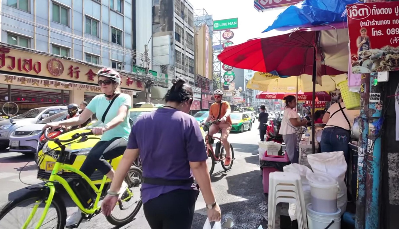Wisatawan bersepeda di jalur alternatif yang tenang dan asri di Bangkok.