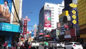 Bus wisata malam dua tingkat di jalanan kota Bangkok dengan latar lampu kota