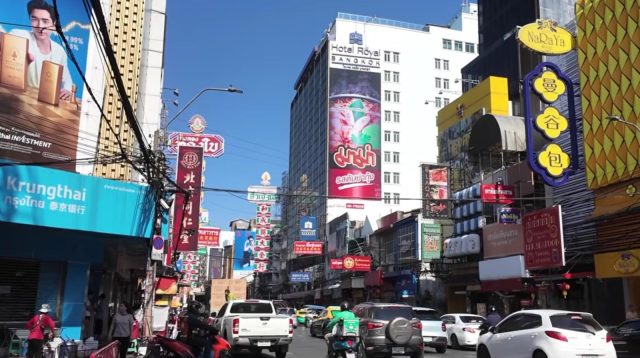 Bus wisata malam dua tingkat di jalanan kota Bangkok dengan latar lampu kota