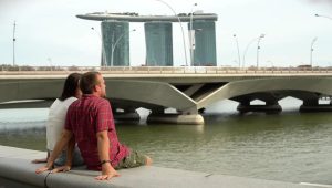 Seorang wanita Indonesia menatap gedung-gedung tinggi Singapura dari kejauhan di pelabuhan Batam.