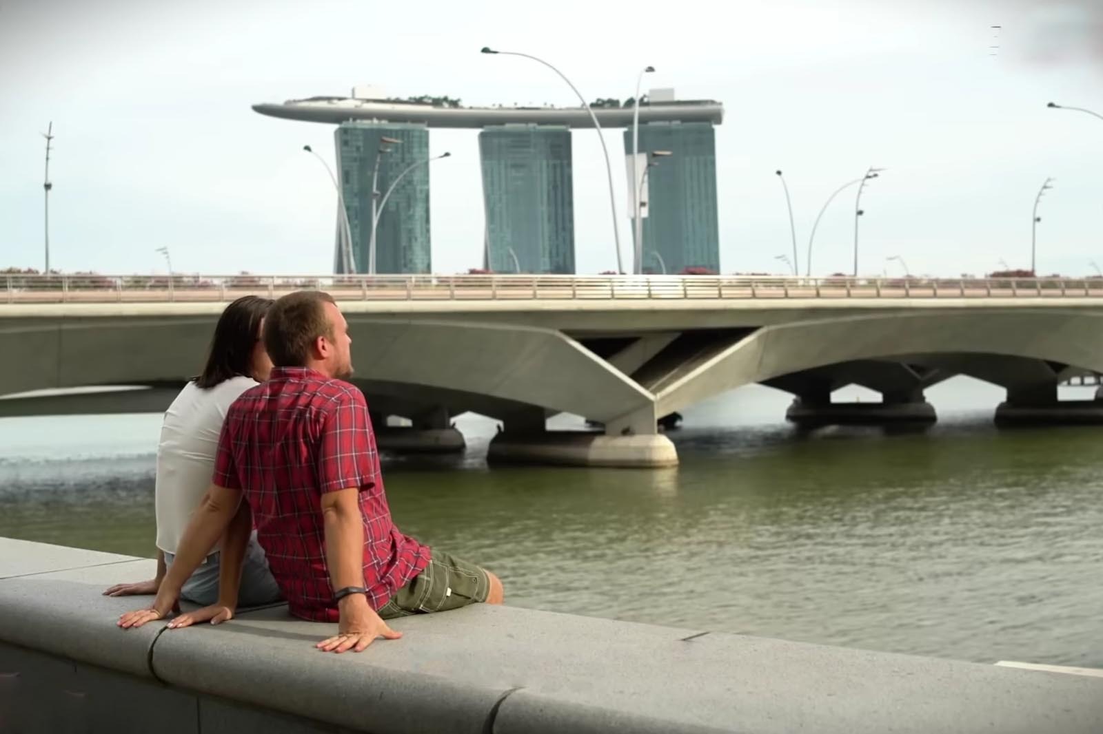 Seorang wanita Indonesia menatap gedung-gedung tinggi Singapura dari kejauhan di pelabuhan Batam.