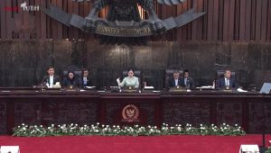 Puan Maharani berdiri tegak di podium ruang pimpinan panggung sidang utama DPR RI Senayan.