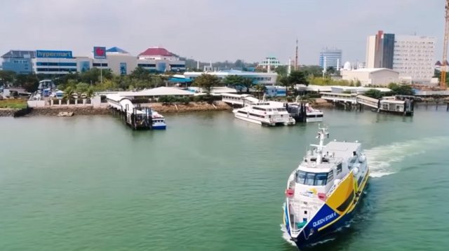 Fasilitas olahraga di pinggir pantai Batam dengan pemandangan kapal feri di kejauhan.