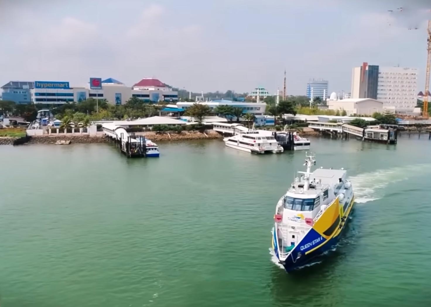 Fasilitas olahraga di pinggir pantai Batam dengan pemandangan kapal feri di kejauhan.