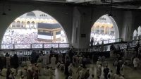 Rombongan jamaah haji Indonesia mengenakan batik khas sedang berjalan di pelataran Masjidil Haram.