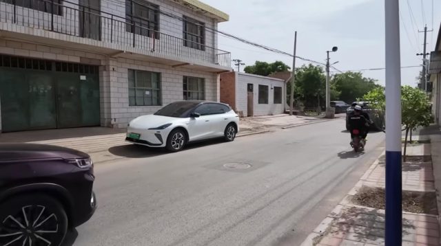 Jalan desa Najiahu yang lebar, mulus tanpa lubang, dengan marka jelas dan deretan pohon di tepinya