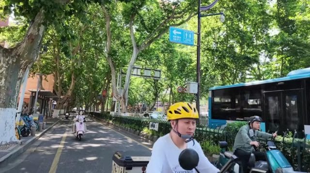 Pemandangan masyarakat Nanjing bersepeda di jalur khusus di tengah kota yang modern