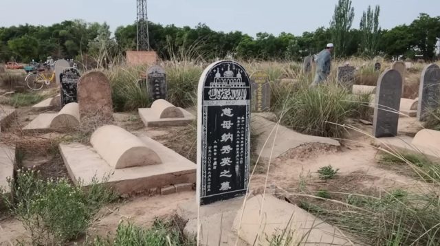 Deretan nisan sederhana yang tertata rapi dikelilingi pepohonan di pemakaman Muslim di Desa Najiahu
