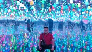 Seorang pria duduk di ruangan terapi cahaya indoor yang dipenuhi lampu warna-warni untuk efek relaksasi