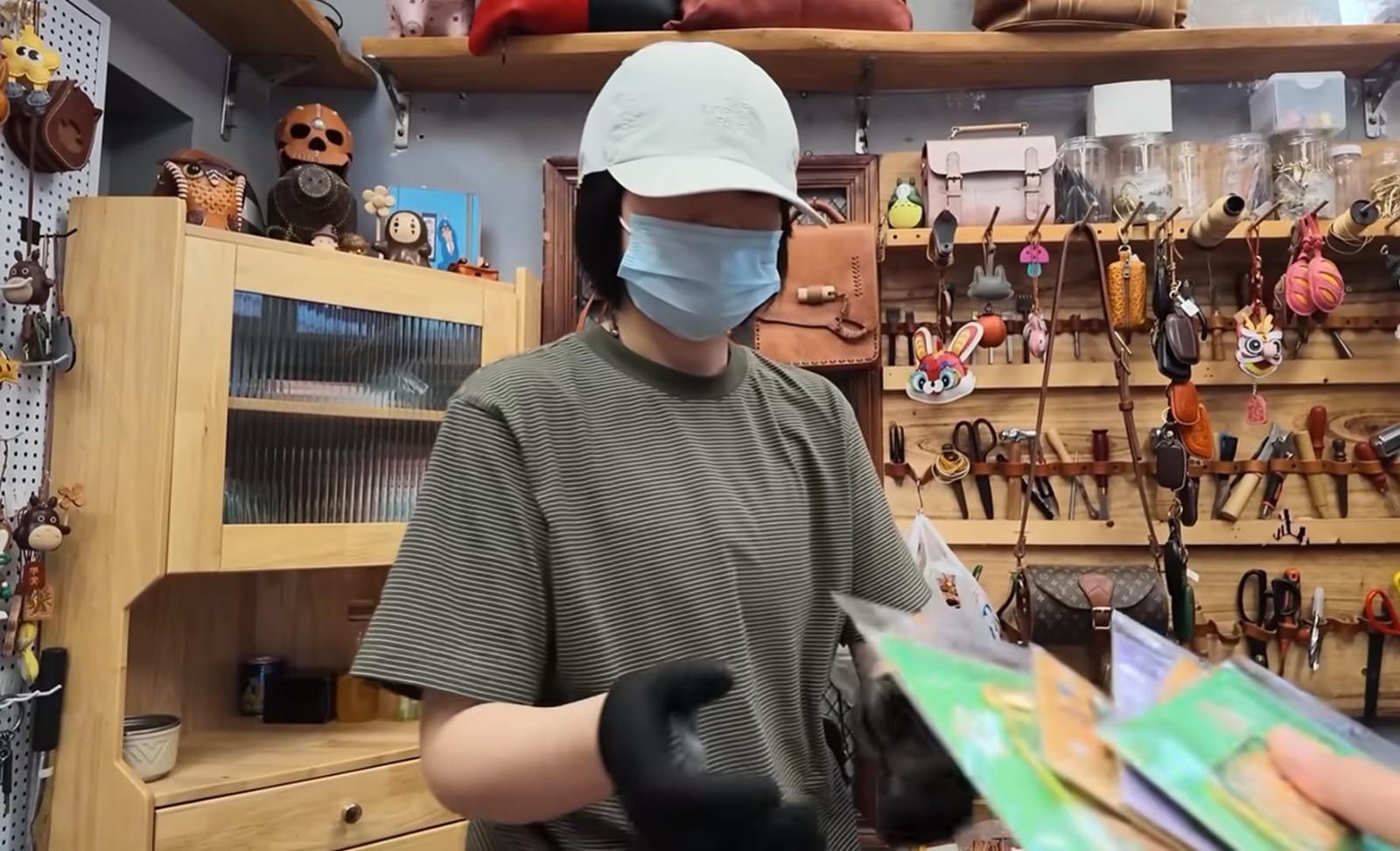 Wirausaha perempuan Qingdao memakai topi dan masker sedang melayani transaksi pelanggan