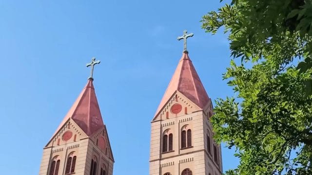 Close-up dua menara beratap merah dengan salib di puncaknya dari Gereja Santo Mikael Qingdao