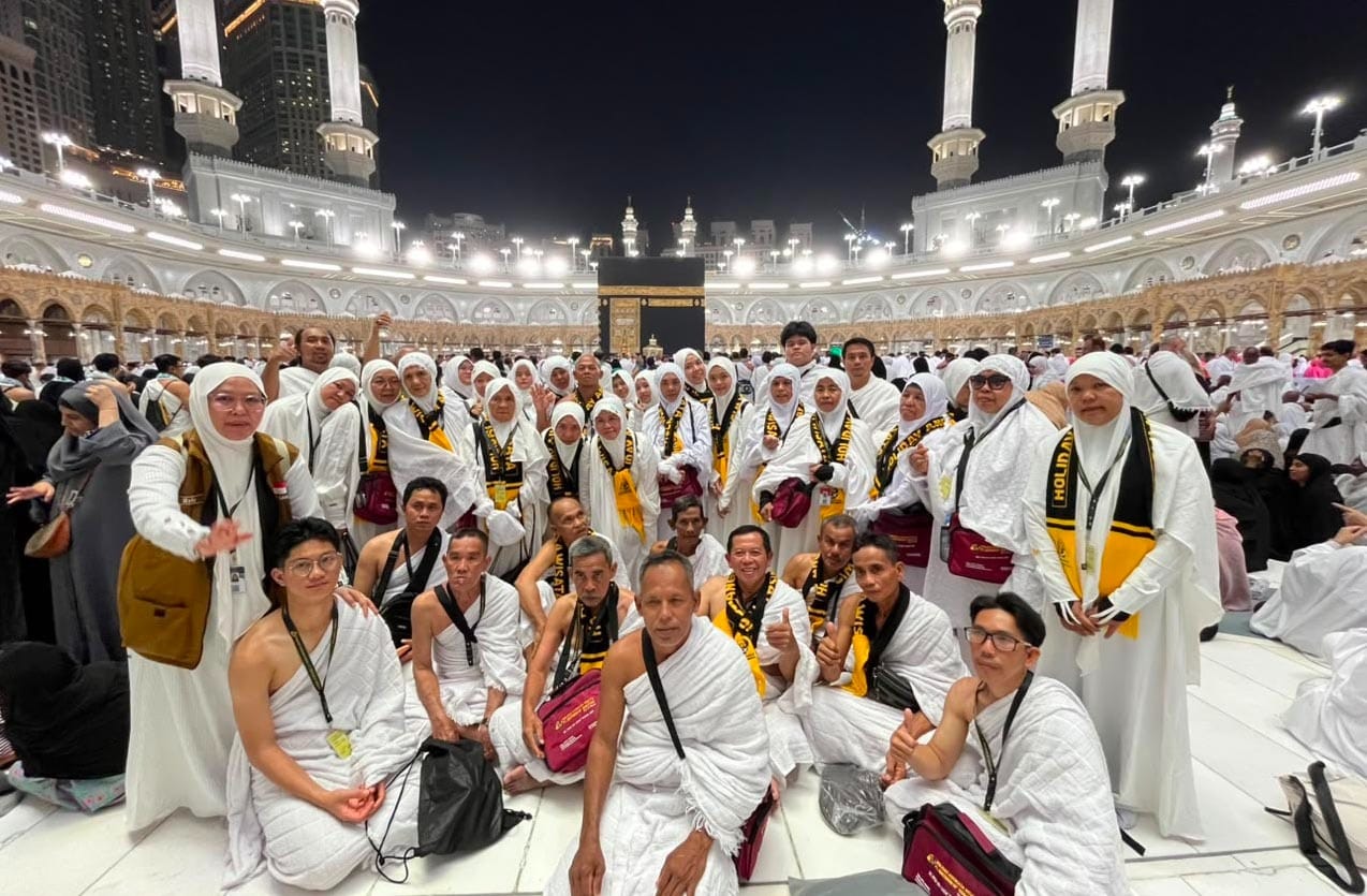 jamaah-umrah-indonesia-di-kakbah Rombongan jamaah umrah Indonesia berkumpul dengan latar belakang Kakbah di pelataran Masjidil Haram yang dipadati lautan manusia