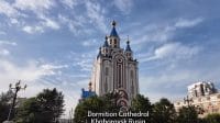 kubah-emas-gereja-dormition-di-khabarovsk Gereja Dormition di Khabarovsk yang menjulang tinggi dengan ciri khas kubah emas dan biru, dikelilingi pepohonan hijau.