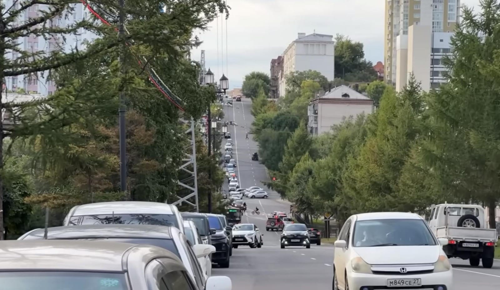 suasana-jalanan-kota-khabarovsk Arus kendaraan dan pejalan kaki di jalanan kota Khabarovsk yang tertib dengan latar perpaduan arsitektur klasik dan modern.