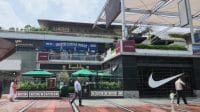 Pemandangan eksterior kawasan komersial kelas atas dengan deretan restoran premium, kafe, dan etalase toko merek global yang berada di kawasan Gurugram