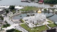 Pemandangan udara Masjid Omar Ali Saifuddien di Brunei Darussalam dengan kubah emas berkilau dan danau buatan yang tenang.