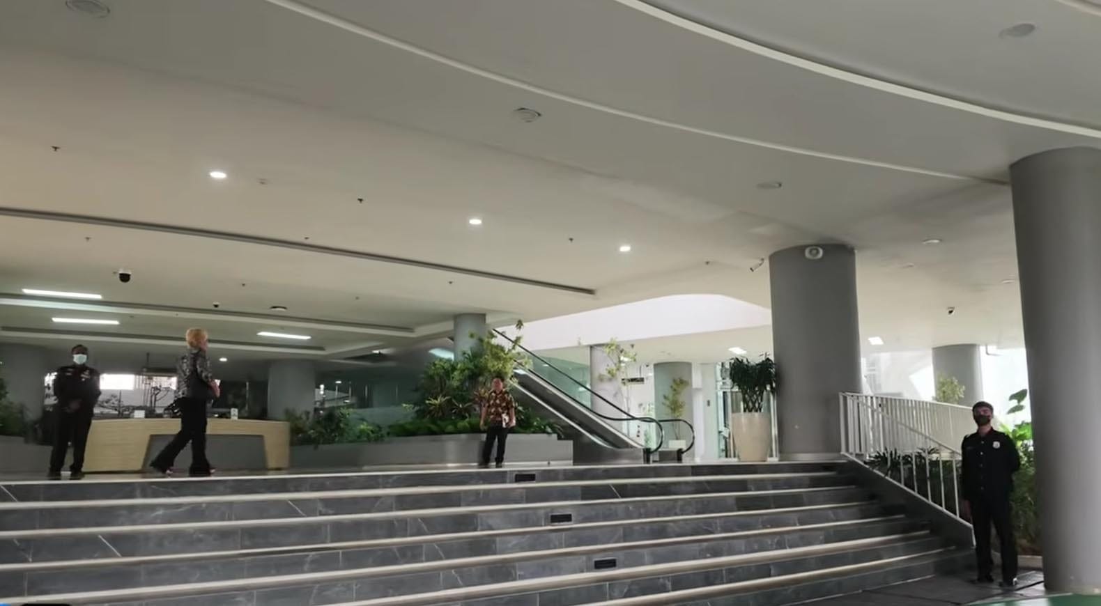 Suasana Ruang Pelayanan Kantor Otorita IKN Petugas aparatur berseragam berdiri menjaga area lobi ruang pelayanan di dalam gedung perkantoran Otorita IKN