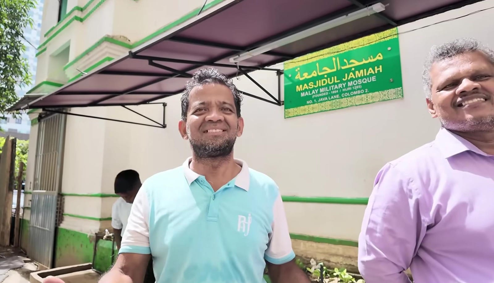 Dua orang pria Muslim Sri Lanka tersenyum ramah di depan bangunan masjid