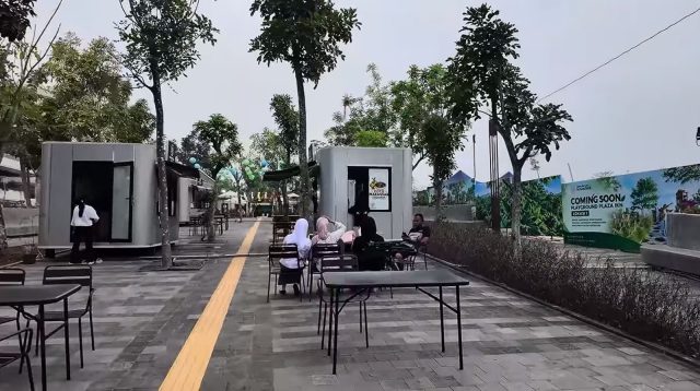 Suasana kawasan pedestrian terbuka modern di IKN dengan lampu jalan dan rambu lalu lintas yang tertata rapi.