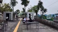 Sekelompok orang duduk santai menikmati waktu di area kafe terbuka bernuansa modern.