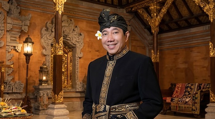 Guruh Soekarnoputra mengenakan busana adat tradisional Bali di dalam ruangan berarsitektur klasik.