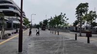 Dua orang berjalan santai menikmati suasana sore di kawasan pejalan kaki terbuka yang rindang di IKN.