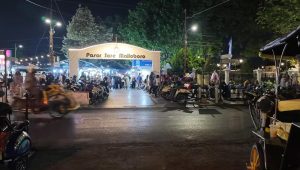 Gerbang masuk Pasar Sore Malioboro yang terang benderang oleh lampu di malam hari.
