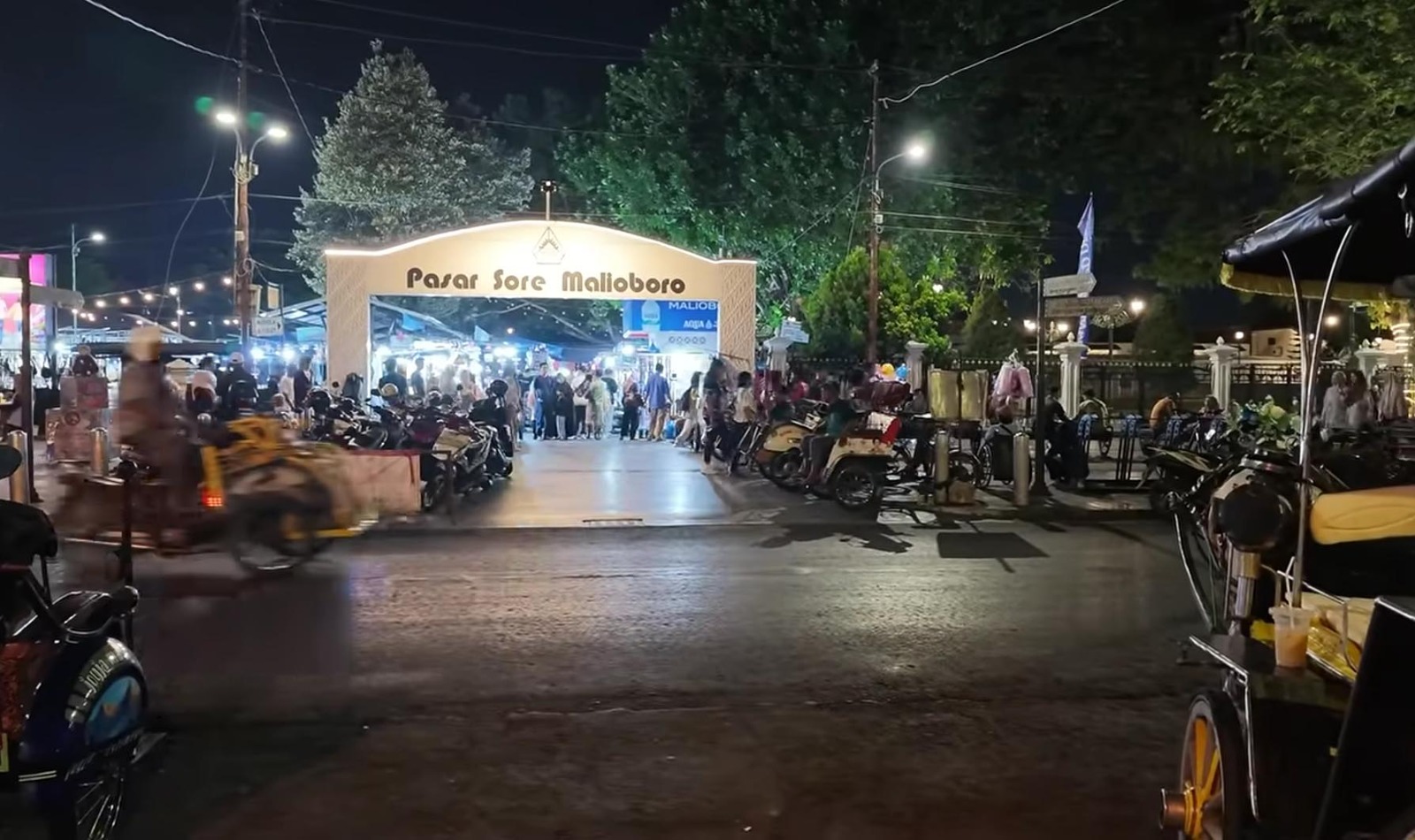 Gerbang masuk Pasar Sore Malioboro yang terang benderang oleh lampu di malam hari.