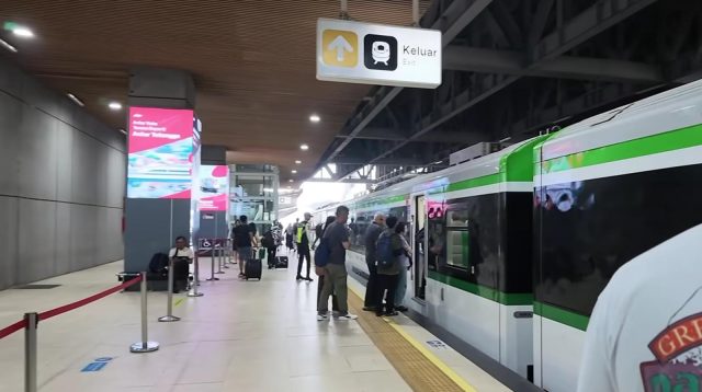 Penumpang sedang mengantre masuk ke dalam rangkaian Kereta Cepat Whoosh di peron stasiun.