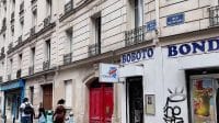 Fasad bangunan klasik di Paris dengan plang bertuliskan BOBOTO di atas sebuah pintu merah