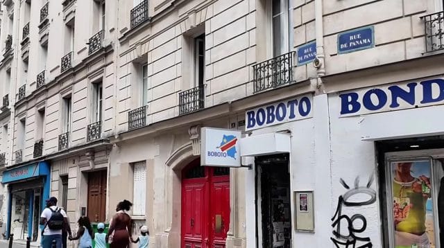 Fasad bangunan klasik di Paris dengan plang bertuliskan BOBOTO di atas sebuah pintu merah