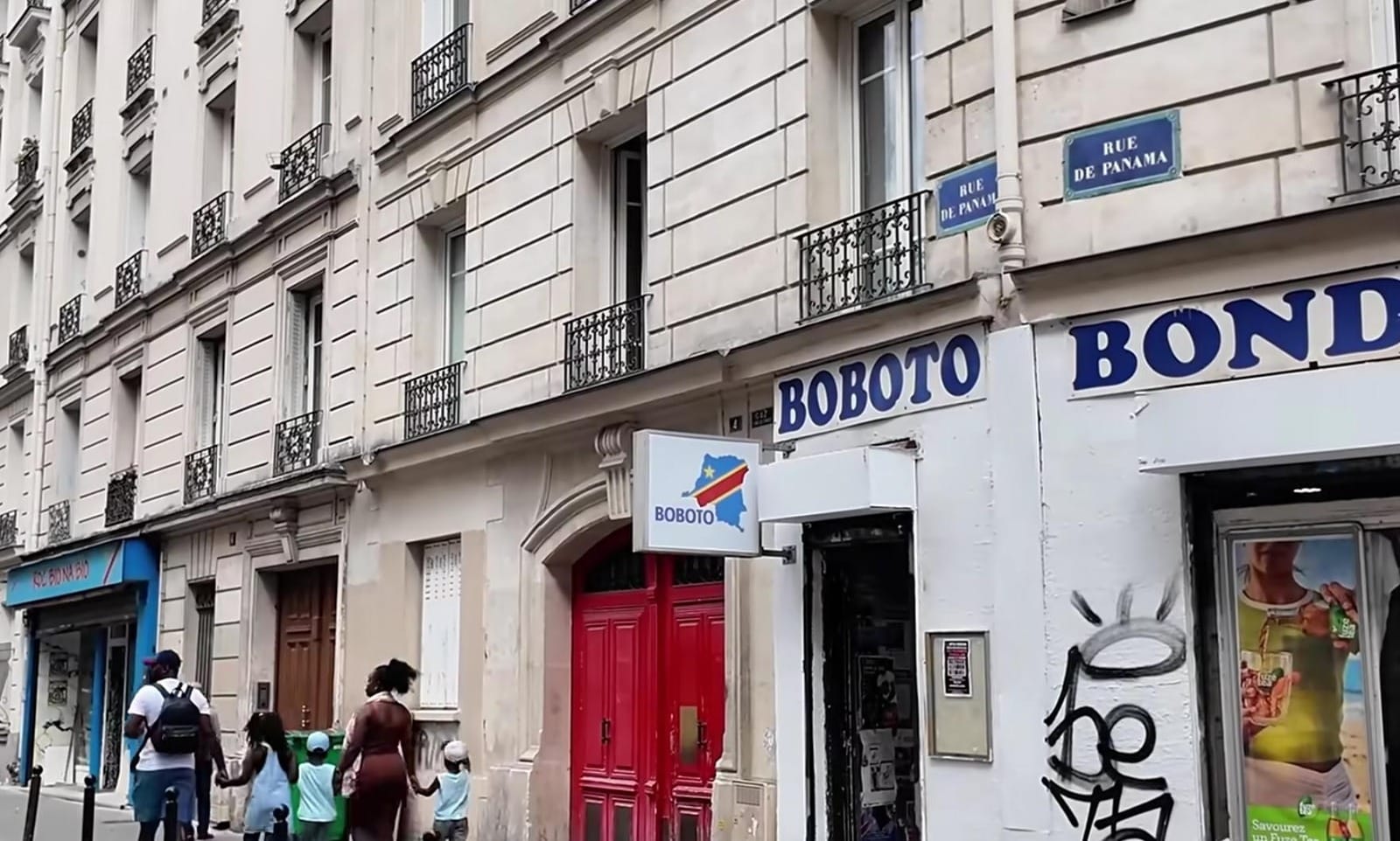 Fasad bangunan klasik di Paris dengan plang bertuliskan BOBOTO di atas sebuah pintu merah