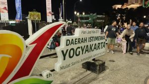 Papan penanda Hari Jadi Ke-271 Daerah Istimewa Yogyakarta dengan keramaian pejalan kaki di Malioboro pada malam hari.